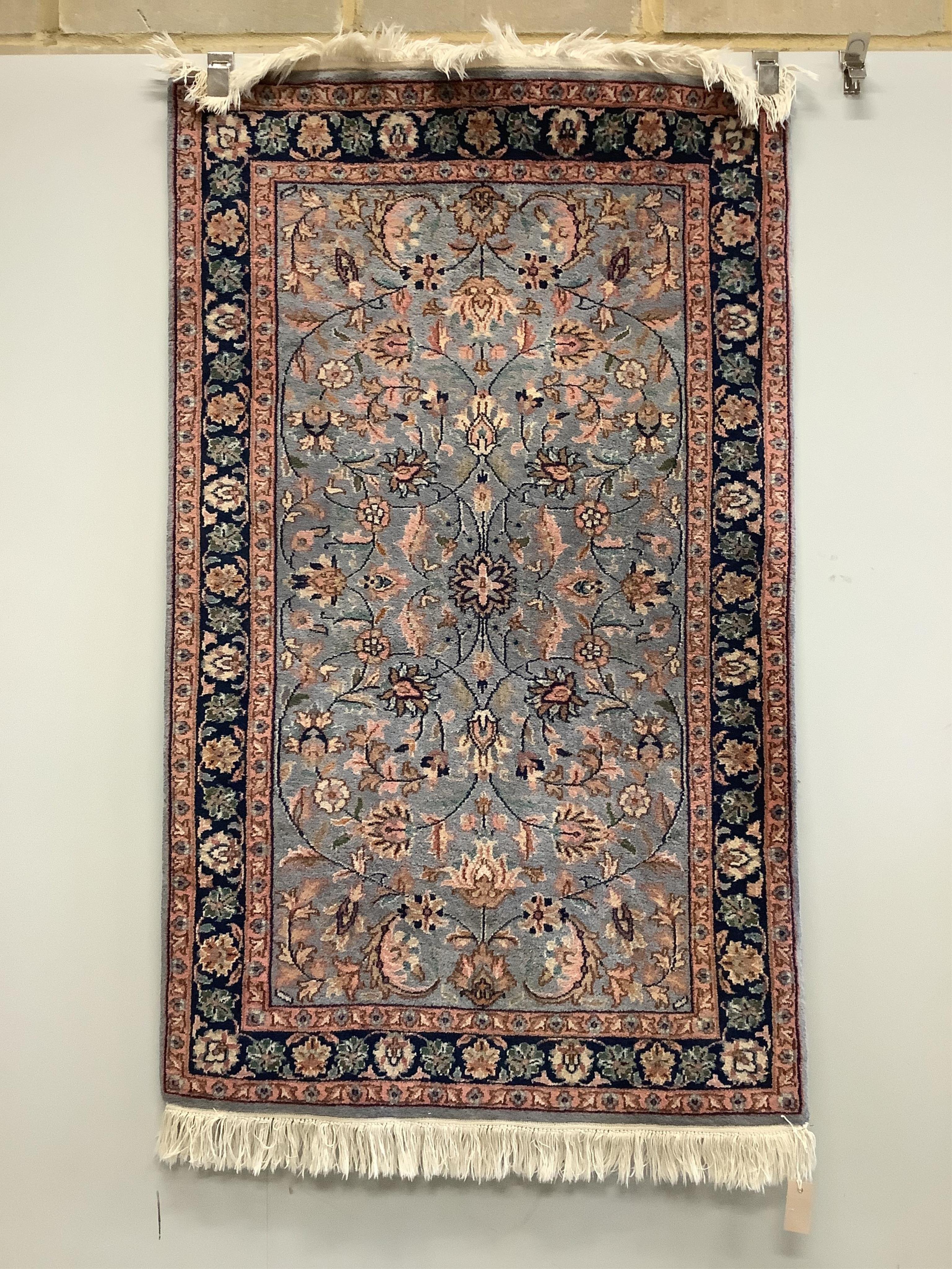 A North West Persian pale blue ground rug, the field with an all over scrolling foliate design, 152 x 93cm. Condition - fair to good